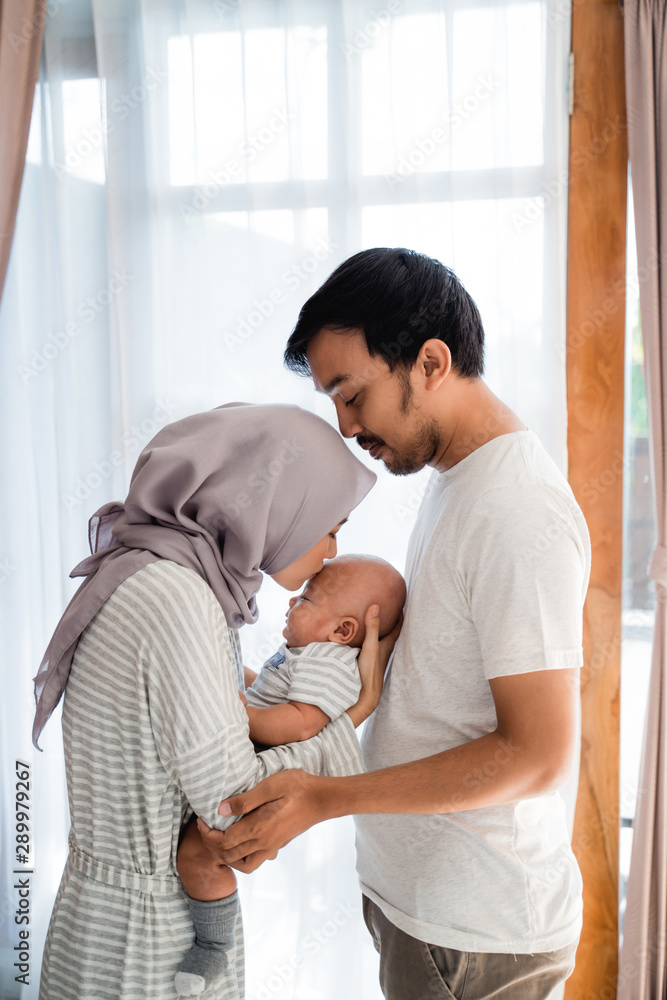 lovely young muslim parent with their newborn baby enjoy time together playing at home lovely young muslim parent with their newborn baby enjoy time together playing at home
