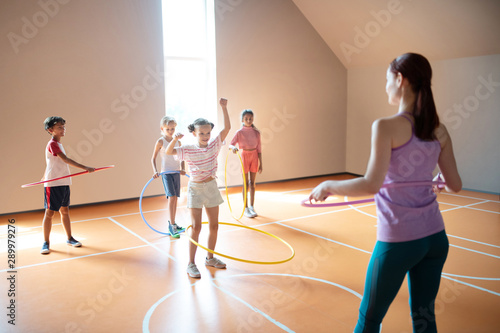 Children trying to roll hula-hoop at the PE lesson