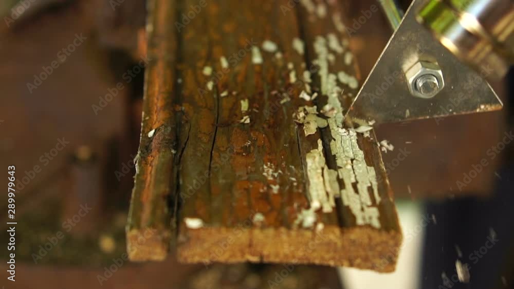 worker using a building hair dryer heats paint on a wooden bar and cleans it with a scraper, slow motion, close-up worker using a building hair dryer heats paint on a wooden bar and cleans it with a scraper, slow motion, close-up
