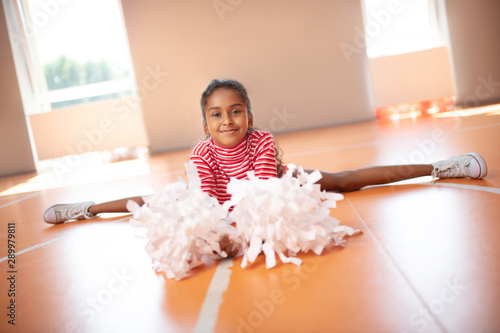 Принти на полотні Girl wearing white sneakers doing leg split while stretching legs