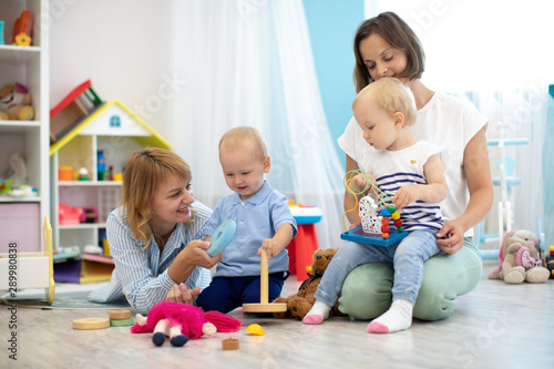 Nursery babies and kindergarten teachers playing with toys in creche