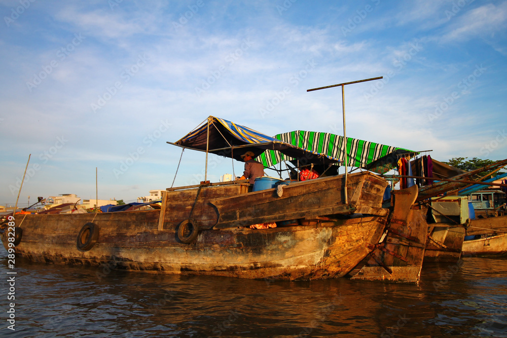 A wooden merchant boat in the famous traditional Cai rang floating market in the province of Can tho that shows the authentic culture and livelihood in the Mekong Delta of Vietnam A wooden merchant boat in the famous traditional Cai rang floating market in the province of Can tho that shows the authentic culture and livelihood in the Mekong Delta of Vietnam