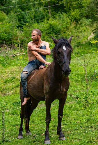 man with a naked torso riding horse