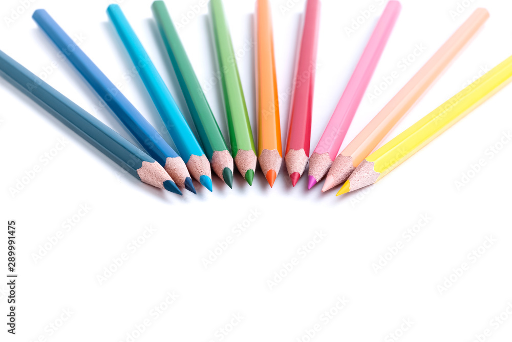 Set of bright sharpened colored wooden pencils lying in a semicircle with their tips to each other with an empty place for text isolated on white background Set of bright sharpened colored wooden pencils lying in a semicircle with their tips to each other with an empty place for text isolated on white background