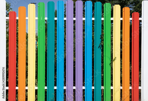 multi-colored aluminum high railing against the blue sky and adult green spaces