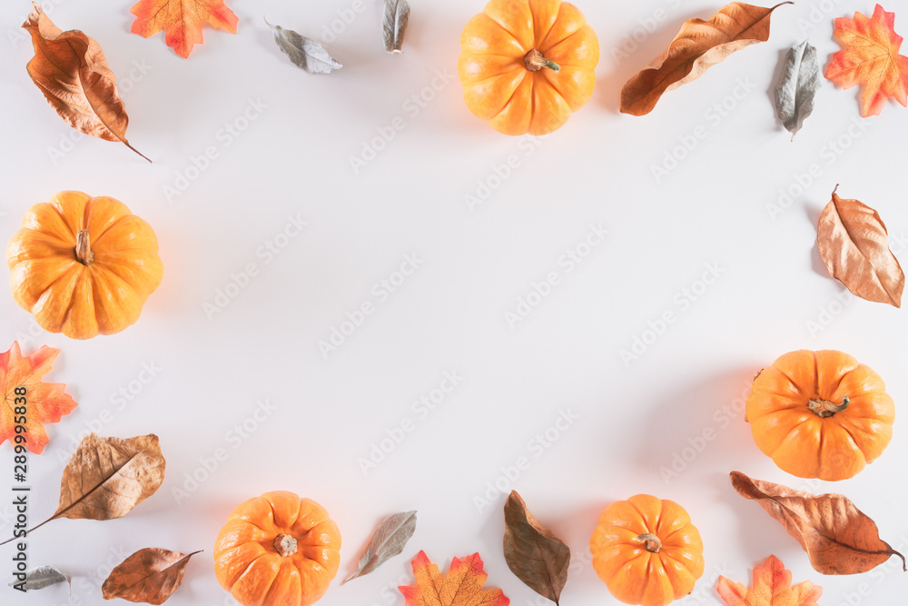 Autumn composition. Orange pumpkin with autumn leaves on white background. Flat lay, top view copy space.