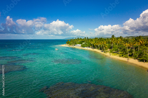 Fototapeta Naklejka Na Ścianę i Meble -  Aerial view of tropical beach with white boat anchored.Samana peninsula,Bahia Principe beach,Dominican Republic.