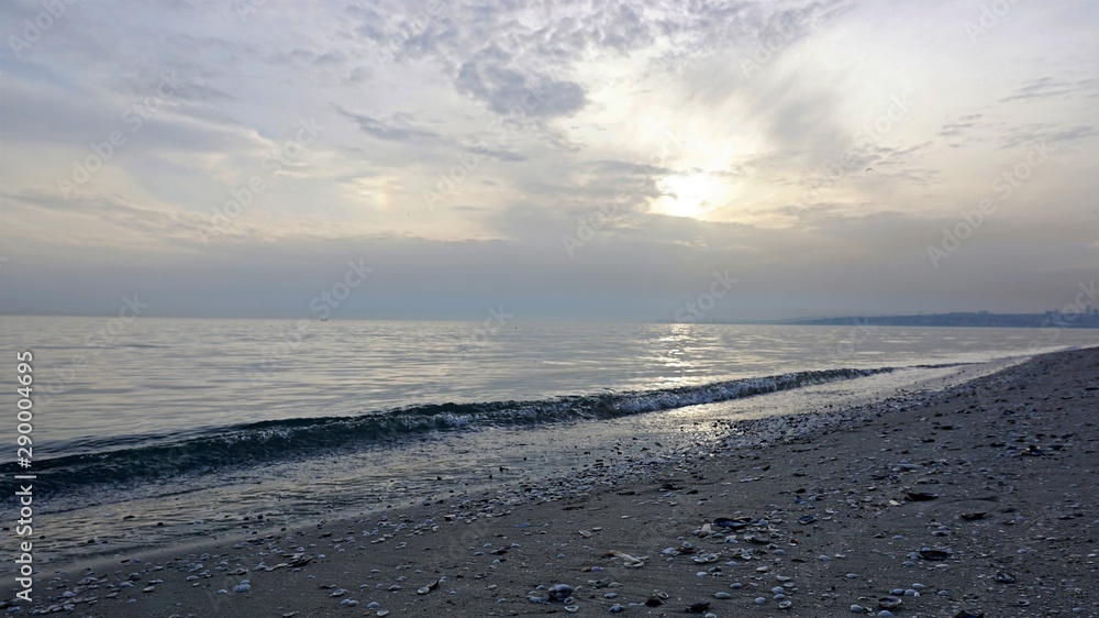 Wavy seascape view from the beach with pebbles and seashells on it. Wavy seascape view from the beach with pebbles and seashells on it.