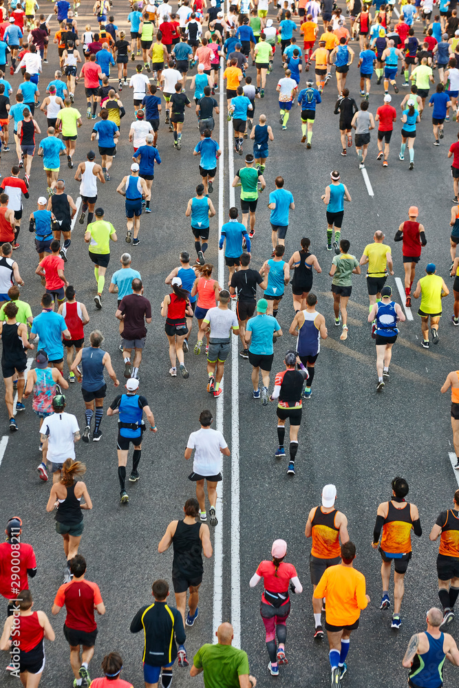 Runners on the street. Athletes in motion. Urban competition. Crowd