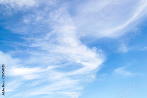Scenic fluffy cirrus and stratus clouds in the stratosphere. Light spindrift clouds high in the blue summer sky. Different cloud types and atmospheric phenomena.