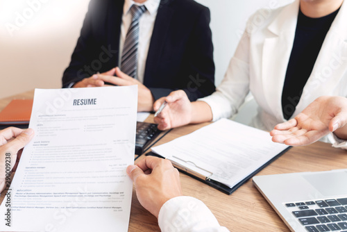 Business consulting candidate employee in suit looking skeptical reading a resume, hr speaking at job interview and recruitment concept.