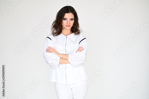 Concept photo portrait of a cute pretty beautiful brunette girl with great makeup in white clothes on a white background. In different poses with emotions.