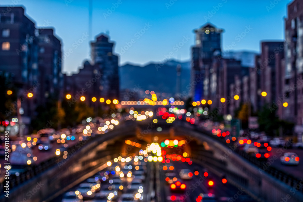 Blurred and Famous view of Tehran,Flow of traffic around Tohid Tunnel with Milad Tower and Alborz Mountains in Background, night cityscape concept