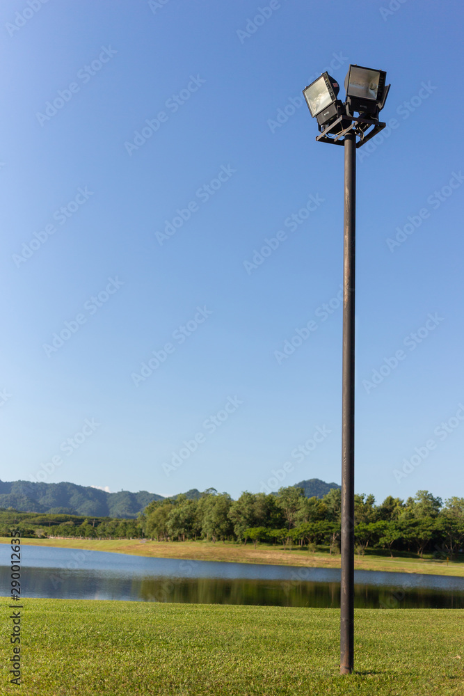 black post garden light with lake and forest and blue sky background