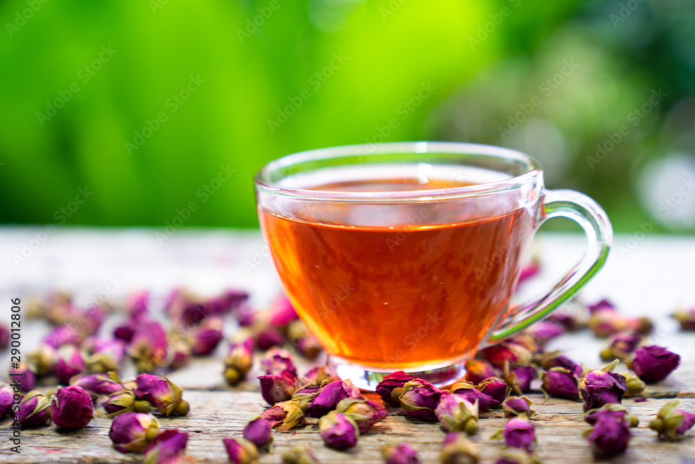Damask rose bud,tTea for holistic health,tea made from tea rose petals in a glass on wooden background Damask rose bud,tTea for holistic health,tea made from tea rose petals in a glass on wooden background