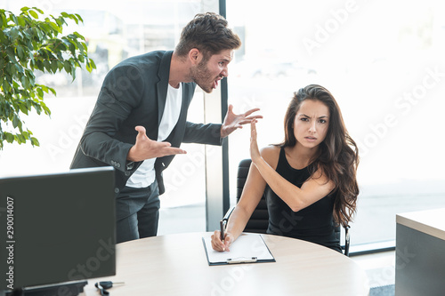 strict boss man swearing at employee woman for bad work at the office