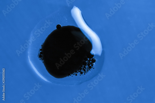 Tableau sur toile Black dot in a water drop blue background