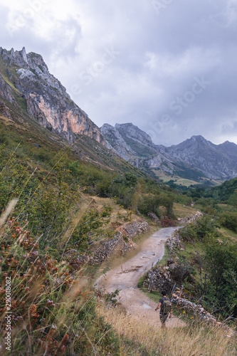 A man walking through the Saliencia Valley (Asturias, Spain) on a cloudy day