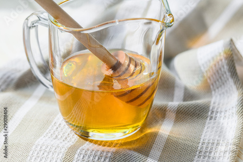 honey with a spoon in a glass jug