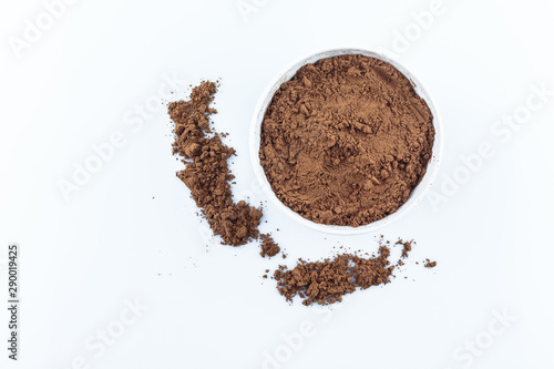 tasty cocoa powder in bowl on white background.