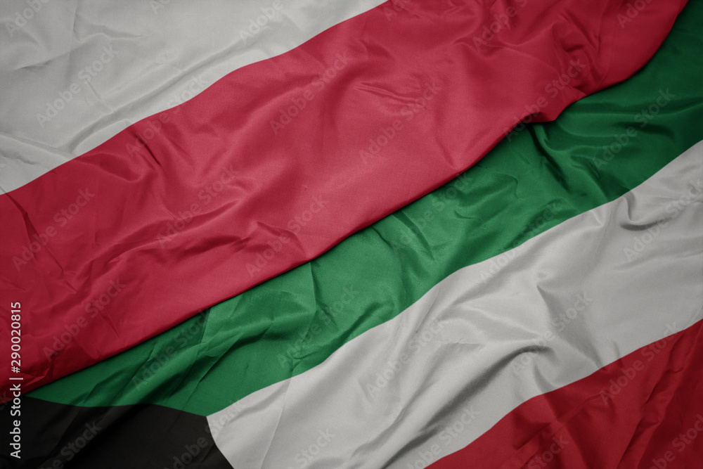 Obraz premium macha kolorową flagą kuwejtu i polską flagą narodową.