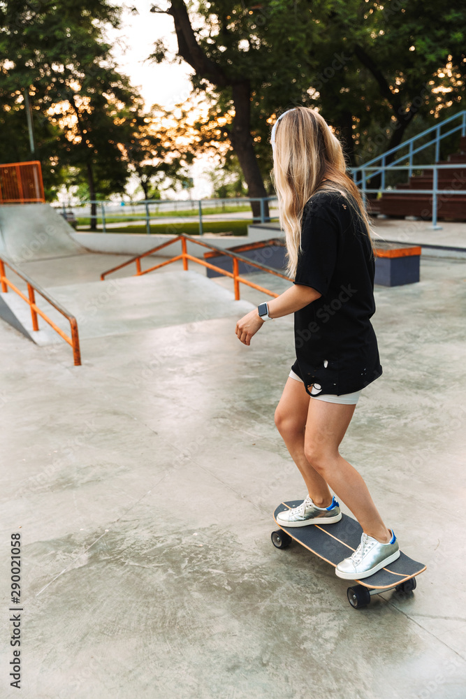 Funky young girl teenager riding on a longboard Funky young girl teenager riding on a longboard