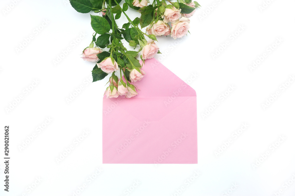 Mockup empty pink envelope and buds of pink roses with place for text, festive white background, copy space Mockup empty pink envelope and buds of pink roses with place for text, festive white background, copy space