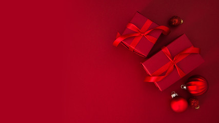 Christmas and New Year holiday background. Xmas greeting card. Christmas gifts on red background top view.	