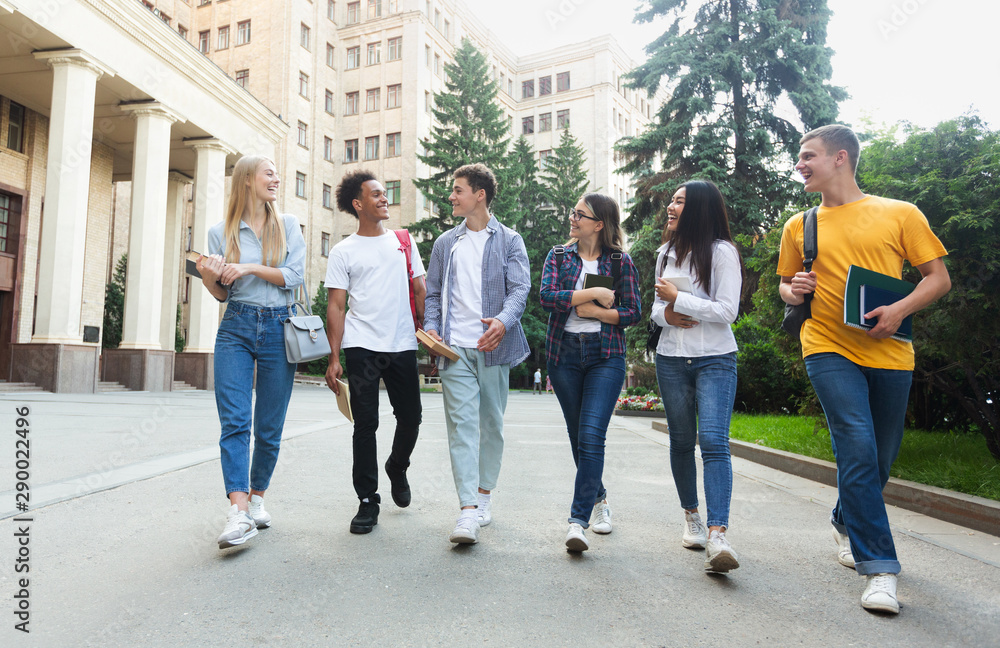 Obraz premium Happy students walking outside the university building