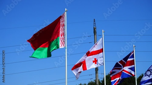 Flags of Belarus, Georgia, Great Britain and Israel on flagpoles. photo