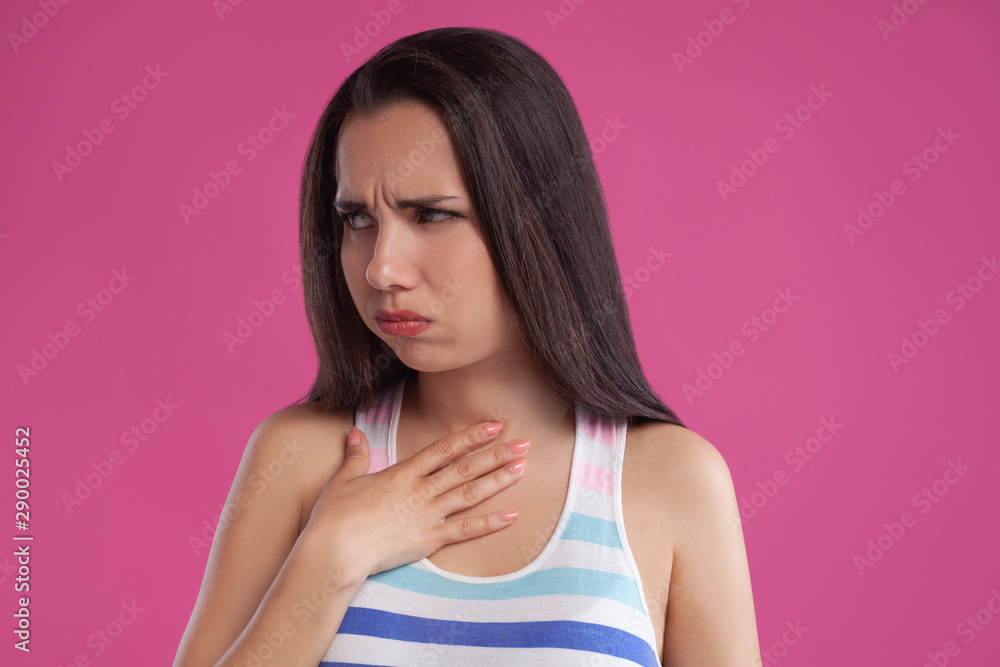 Brunette woman with long hair, dressed in colorful striped shirt, posing against pink studio background. Sincere emotions. Close-up. Brunette woman with long hair, dressed in colorful striped shirt, posing against pink studio background. Sincere emotions. Close-up.