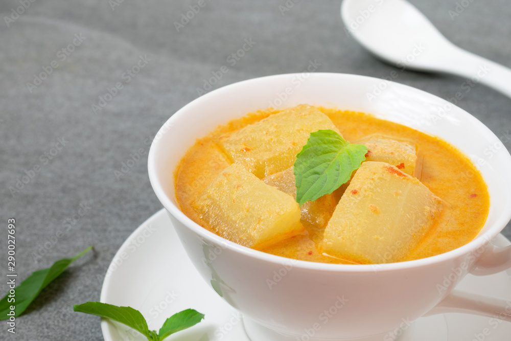 Coconut milk curry with winter melon in white bowl on table. Coconut milk curry with winter melon in white bowl on table.