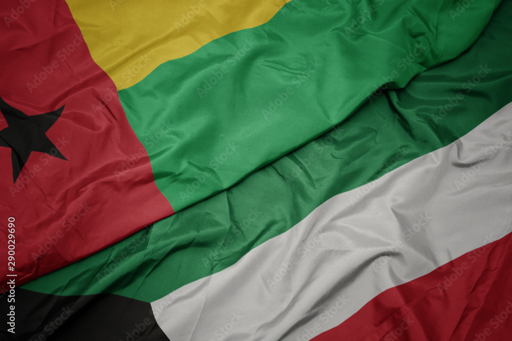 waving colorful flag of kuwait and national flag of guinea bissau. waving colorful flag of kuwait and national flag of guinea bissau.