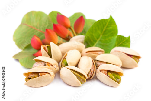 Red pistachio nuts with leaves on white background