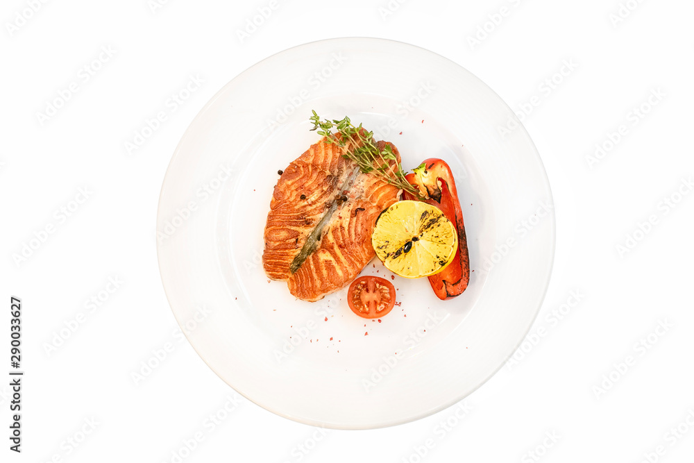 Grilled salmon steak with grilled lemon and vegetables isolated on white background Grilled salmon steak with grilled lemon and vegetables isolated on white background
