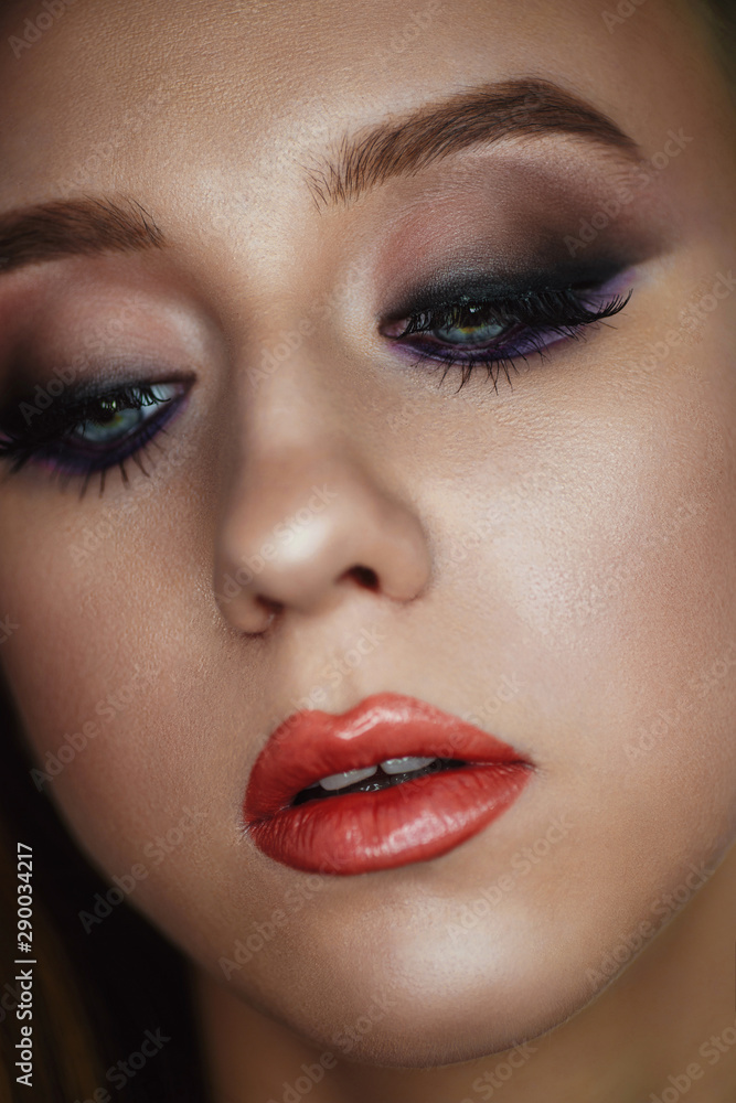Portrait of a young woman with beautiful evening make-up on a dark background Portrait of a young woman with beautiful evening make-up on a dark background