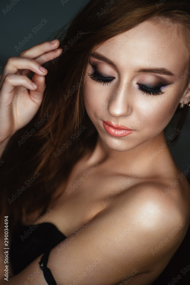Portrait of a young woman with beautiful evening make-up on a dark background Portrait of a young woman with beautiful evening make-up on a dark background