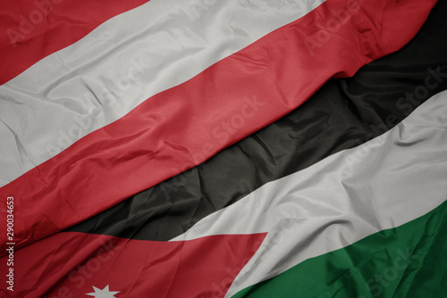 waving colorful flag of jordan and national flag of austria.