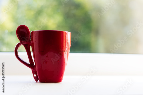 Close-up of red ceramic cup and spoon.