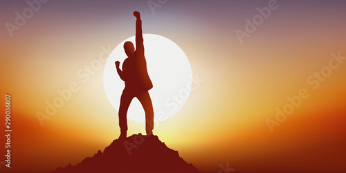 Concept du leadership avec un homme qui exprime sa joie en levant le point en signe de victoire en atteignant le premier le sommet d’une montagne