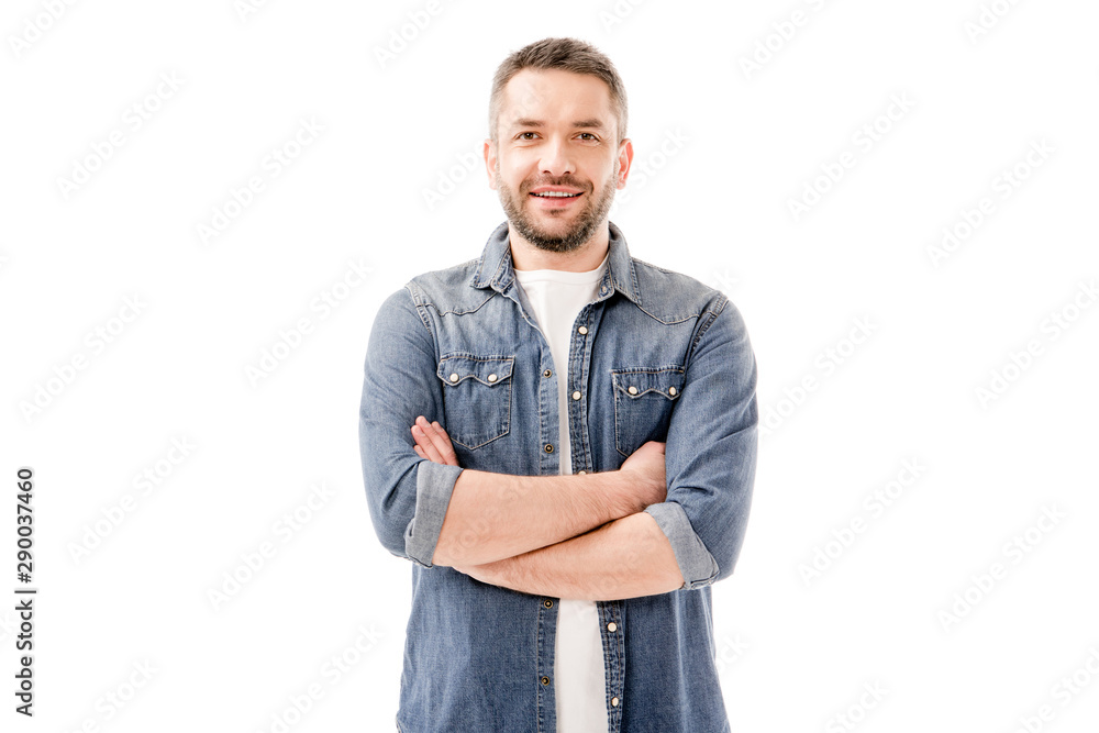 front view of smiling bearded man in denim shirt standing with crossed arms isolated on white - obrazy, fototapety, plakaty 