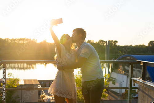 Handsome man and young woman having fun spend time together and taking selfie