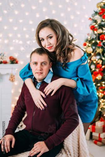 young couple on the background of Christmas tree and Christmas decoration, new year and Christmas, cozy and beautiful