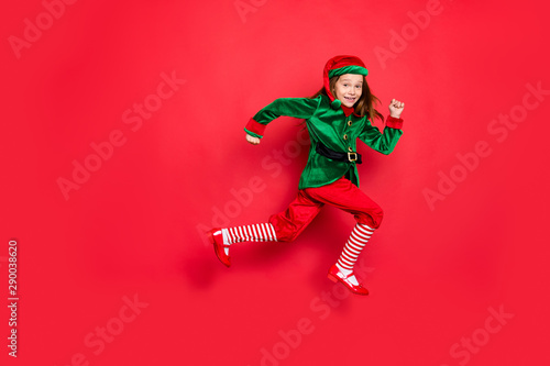 Full length body size view of nice attractive cheerful cheery funny funky carefree small little pre-teen elf having fun running marathon isolated over bright vivid shine red background