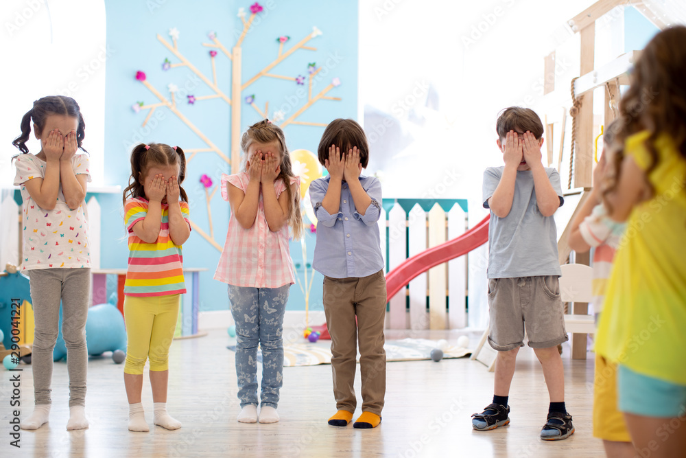Kindergarten pupils kids cover their eyes at the instruction of their teacher during a class activity Kindergarten pupils kids cover their eyes at the instruction of their teacher during a class activity