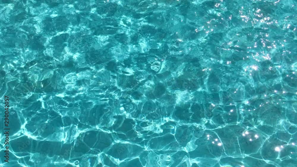 Rippled water surface in swimming pool. Blue water surface background Rippled water surface in swimming pool. Blue water surface background
