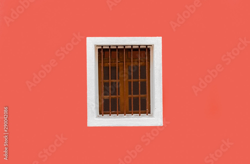 Beautiful background photo of Exterior wall, painted fresh with solid color of peach. The wall is clean, plain and a Vintage Wooden Window with white outline is adding further glam. -Image photo