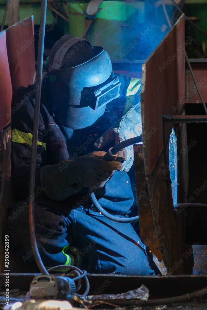 Welder working on ship repairing yard Welder working on ship repairing yard