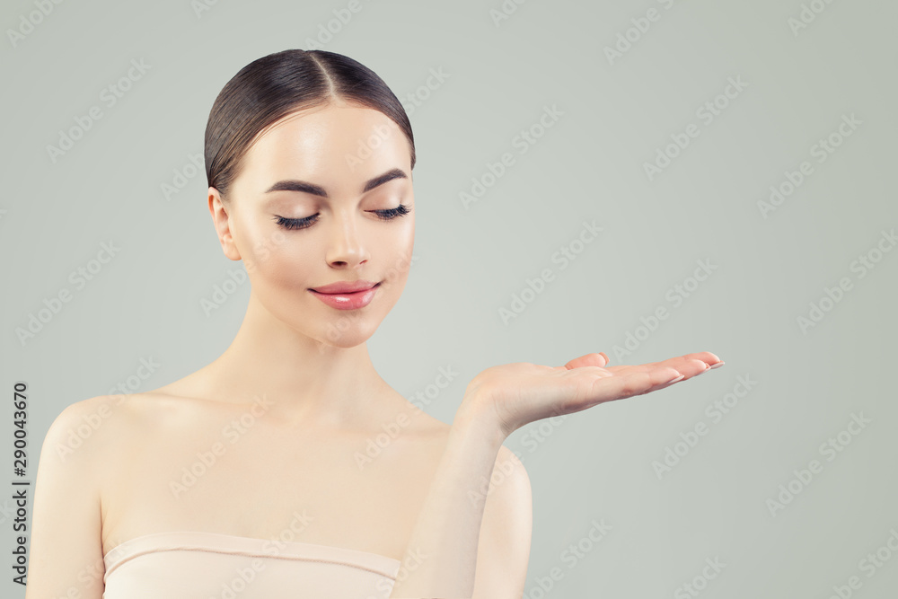 Cute woman showing empty copy space on open hand Cute woman showing empty copy space on open hand