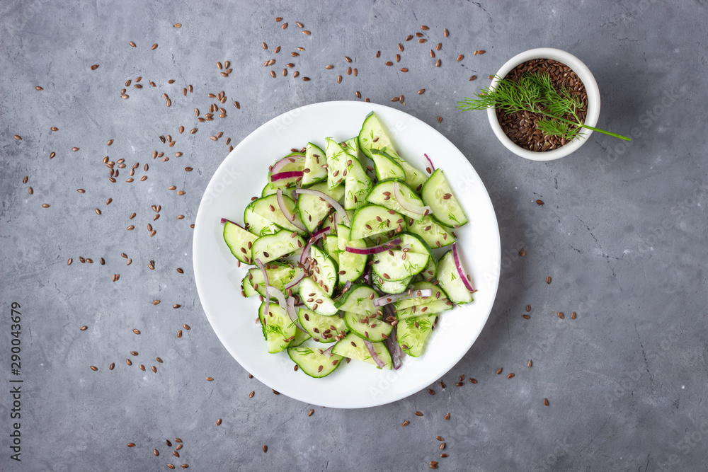 Fresh cucumber salad with flax seeds on gray stone background. Top view. Fresh cucumber salad with flax seeds on gray stone background. Top view.